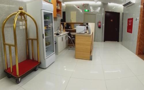 a kitchen with a refrigerator and a red luggage cart at درة الشرق للشقق المخدومة in Al Madinah