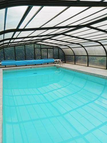 une piscine intérieure avec toit dans l'établissement 17th century house with swimming pool, à Pleurtuit