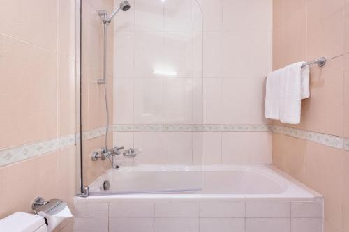 a bathroom with a bath tub with a shower at Live and experience Al Marjan Island 1BR in Ras al Khaimah