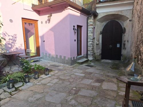 a pink building with a door and a courtyard at La cascina della vigna del viandante in Abbadia Lariana