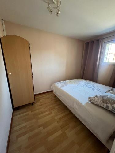 une petite chambre avec un lit et une armoire dans l'établissement Appartement T2 Cosy, à Saint-Éloy-les-Mines