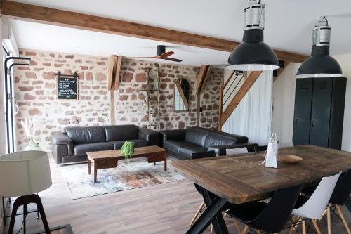 un salon avec une table et un canapé dans l'établissement Grange La Rouge - gîte Corrèze, à Ayen