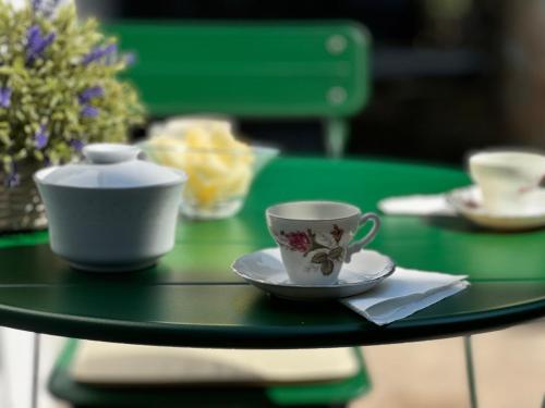 a green table with cups and saucers on it at Encanto de Xisto in Piódão