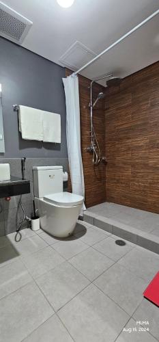 a bathroom with a toilet and a shower at Serenity by Zen Residences at The Radiance Manila Bay in Manila