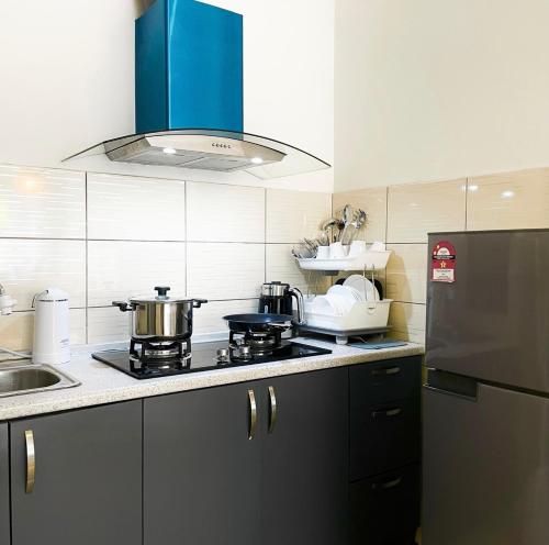 a kitchen with a stove and a refrigerator at Mizu Homestay Kea Farm 10mins to BOH in Cameron Highlands