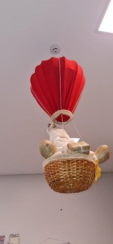a chandelier with a red umbrella and a basket at Hotel Ficare Torres in Torres
