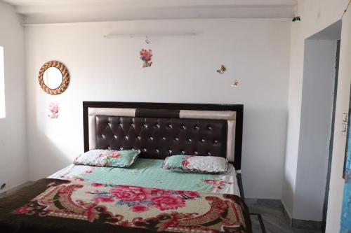 a bedroom with a bed with a blanket and pillows at Anne Guest House in Jodhpur