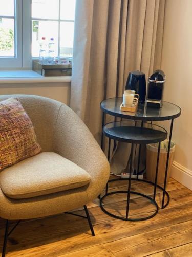 a living room with a chair and a side table at Hotel Villa Verdi in Knokke-Heist