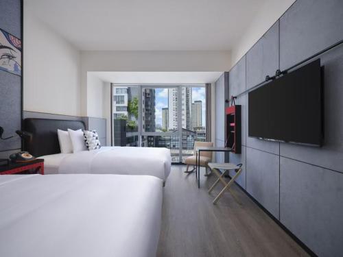 a hotel room with two beds and a flat screen tv at Moxy Ningbo Old Bund in Ningbo