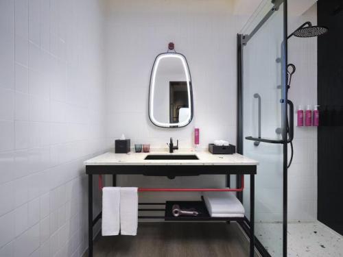 a bathroom with a sink and a mirror at Moxy Ningbo Old Bund in Ningbo