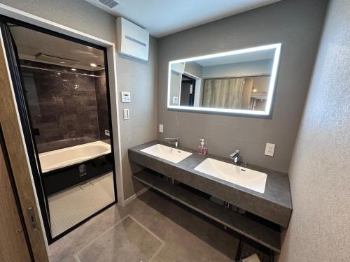 a bathroom with two sinks and a large mirror at COTO Premium Shibuya B in Tokyo