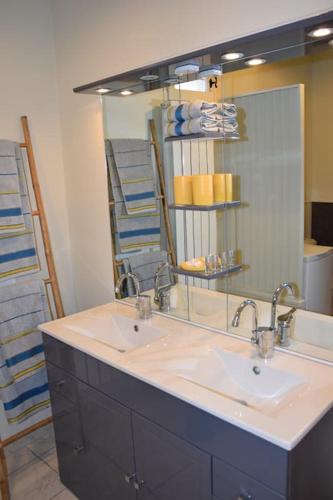 une salle de bain avec deux lavabos et un grand miroir dans l'établissement Moulin des Gypses Gîte l'Oliveraie, à Mormoiron