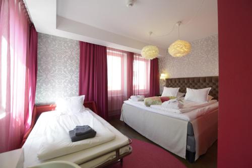 a hotel room with two beds and pink curtains at Best Western Hotel Akersberga in Åkersberga