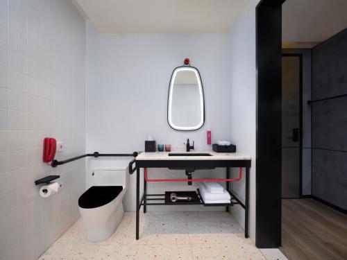 a bathroom with a sink and a mirror at Moxy Ningbo Old Bund in Ningbo