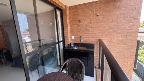 a balcony with a table and chairs and a brick wall at Flat Comfort La Belle Formosa - Cabedelo in Cabedelo