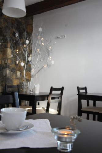 a table with a white bowl on a table with lights at Blyzhche Neba in Yablunytsya