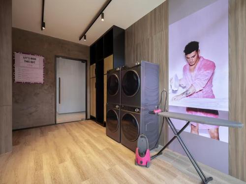 a room with a painting of a man on a wall at Moxy Ningbo Old Bund in Ningbo