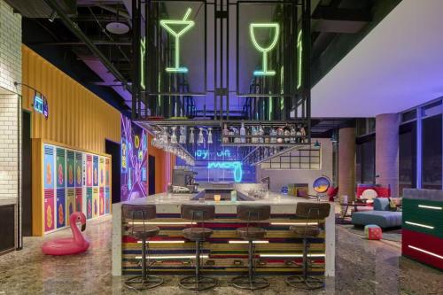 a room with a bar with stools and a bar counter at Moxy Ningbo Old Bund in Ningbo