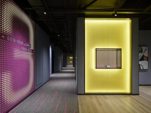 a hallway with a yellow door and a pink wall at Moxy Ningbo Old Bund in Ningbo