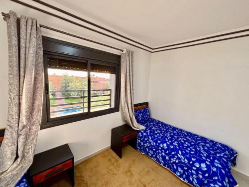 a bedroom with a blue bed and a window at Cabane Ouirgane in Aït Zat
