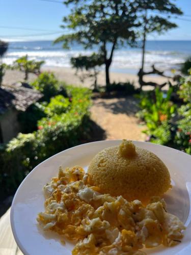 a plate of food on a table next to the beach at Pousada Hanalei in Itacaré