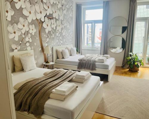 a white bedroom with two beds and a mirror at Zentrales Apartment mit Balkon in Vienna
