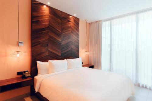 a bedroom with a white bed and a wooden wall at CALIXTA Hotel in Playa del Carmen