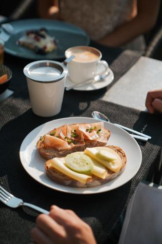 a plate of food with a sandwich on a table at Hotel Seehof Nature Retreat in Naz-Sciaves