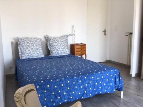 - une chambre avec un lit bleu avec des oreillers et une croix dans l'établissement NICE PARC PHOENIX, à Nice