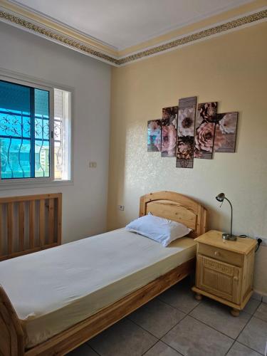 una camera da letto con un letto e una finestra di La Colline de Chott Meriem appartements a Sousse