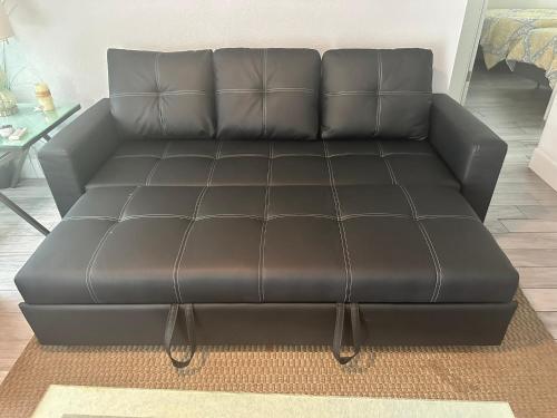 a black leather couch in a living room at Sun and Sea By Beachside Management in Siesta Key