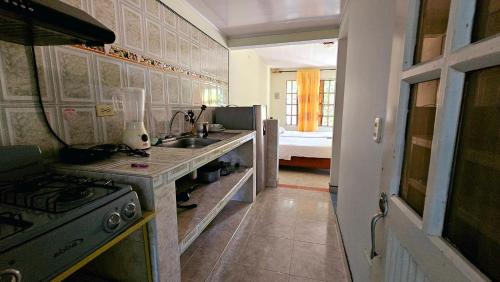 a kitchen with a stove and a sink and a bed at Casa turistica Portones del mirador in Monterrey