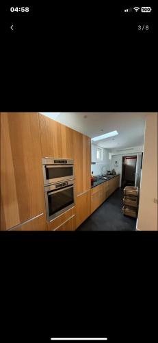 - une cuisine avec des placards en bois et un four dans l'établissement Villa magnifique vue mer, à Marseille