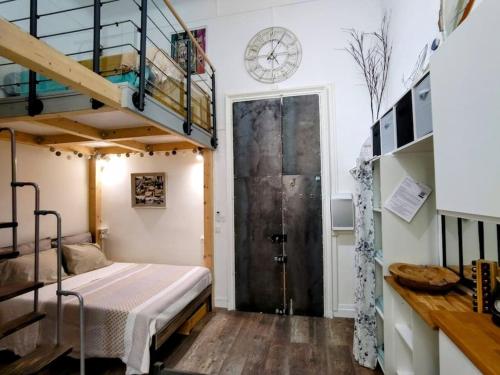 - une chambre avec des lits superposés et une porte avec une horloge dans l'établissement Studio Mimosa Duplex in old town, 200m to beach, à Nice