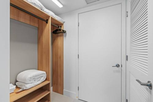 a bathroom with a closet with white towels on a shelf at New Luxury Apartment at Downtown Miami in Miami