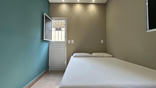 a bedroom with a large bed and a window at Suíte 01 • Praia das Pitangueiras in Guarujá