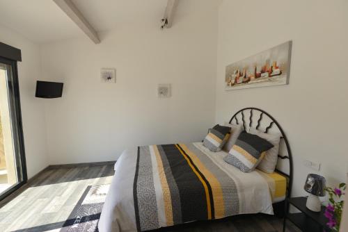 une chambre avec un lit dans une pièce aux murs blancs dans l'établissement Chez Véronique et Jean Daniel, à Maubec