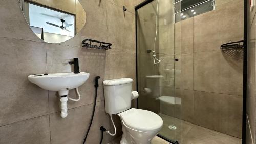 a bathroom with a toilet and a sink and a shower at Suíte 08 • Praia das Pitangueiras in Guarujá