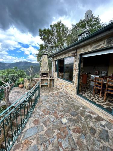 a stone patio with a view of the mountains at Casa do Passadiço in Espiunca