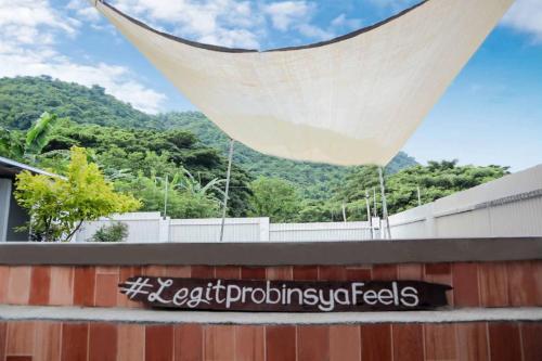awning over a fence with mountains in the background at Puting Bakod- Vacation Home with Mountain & Lake View in Jalajala