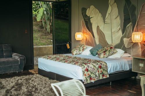 a bedroom with a bed with a large painting on the wall at Hotel Terra Tacuara in Armenia