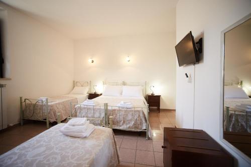 a hotel room with two beds and a television at il Monastero di Bevagna in Bevagna