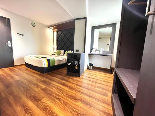 a hotel room with a bed and a mirror at Glitz Hotels The Pacific - Nr Solitaire Corporate Park in Mumbai