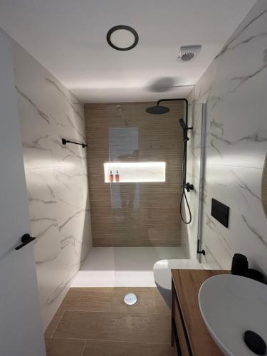 a bathroom with a shower and a toilet and a sink at Apartamentos Perseo Albir in Albir