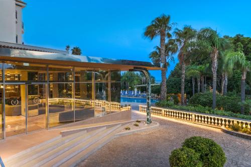 an exterior view of a house with glass at Sant Alphio Garden Hotel & SPA in Giardini Naxos