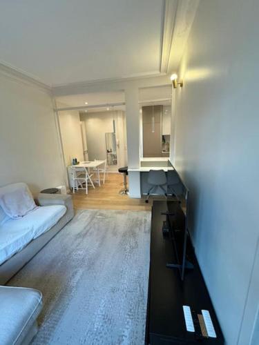 un salon avec un canapé et une table dans l'établissement Charmant Appartement Alésia, à Paris