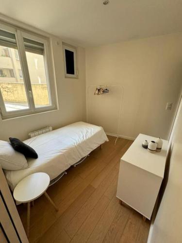 une petite pièce avec un lit et une fenêtre dans l'établissement Charmant Appartement Alésia, à Paris