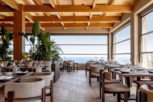 a restaurant with tables and chairs and a view of the ocean at Elios Hill in Hersonissos