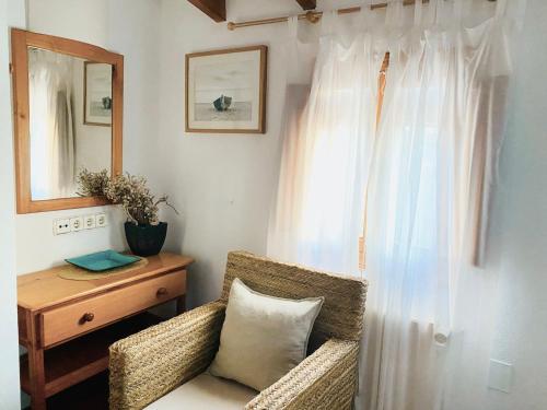 a room with a chair and a table and a mirror at Ses Oliveres in Cala Saona