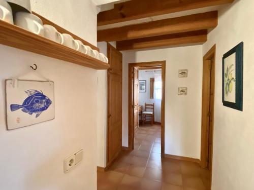 a hallway in a house with white walls and wooden ceilings at Ses Oliveres in Cala Saona